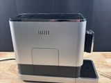 a silver coffee machine sitting on top of a wooden table