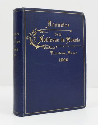 un livre bleu orné d'inscriptions dorées, posé sur une surface blanche