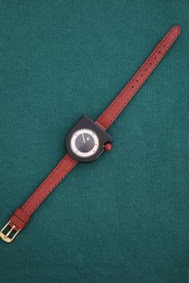 a close up of a wrist watch on a green surface
