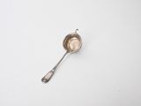 a spoon that is sitting on a white surface