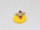 an image of a diamond and ruby ring sitting on a yellow sponge