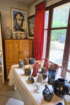 a table with many vases on it in front of a window