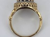 a close up of a gold ring with a blue stone in it