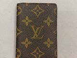 un portefeuille Louis Vuitton posé sur une surface blanche