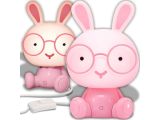 a pink rabbit with glasses sitting next to a toothbrush