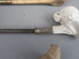a white figurine of a head on a cane next to a bone