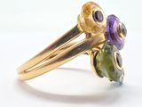 an image of a close up of a yellow gold ring with purple and green stones