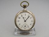 a silver pocket watch sitting on a clear stand
