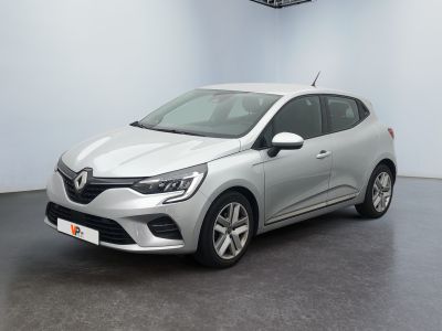 Une voiture argentée est garée dans une pièce au sol noir.
