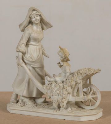 statue représentant une femme et un enfant avec une charrette chargée de moutons