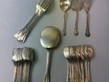 beaucoup de cuillères en argent et de cuillères à soupe sur une table