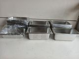 four pans of food are lined up on a counter