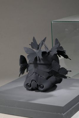 une sculpture représentant un casque de stormtrooper exposée dans une vitrine