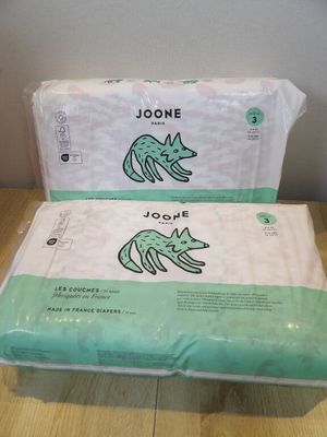 two packages of white toilet paper sitting on top of a wooden table