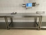 une table en acier inoxydable sur laquelle est posé un écran