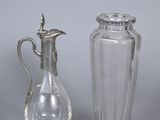deux vases en verre et un pichet en métal argenté posés sur une table