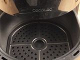 a black and silver air fryer sitting on a table