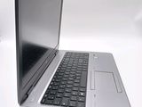 a silver laptop with a black keyboard on a white surface