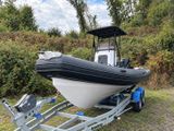 a boat on a trailer parked in the grass