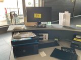 a desk with a computer, printer, and other electronics on it