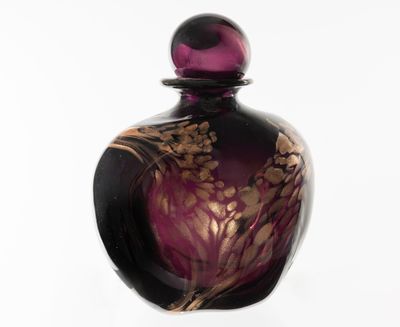 une bouteille en verre violette ornée d'un motif floral