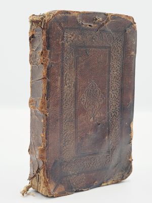 un vieux livre posé sur une surface blanche