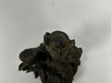 a small figurine of a monkey sitting on a white surface