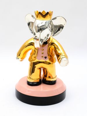 statue of an elephant with a gold crown on a pink base