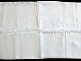une feuille de papier blanc posée, pliée, sur une table noire