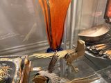 a glass display case with a vase and two birds on it