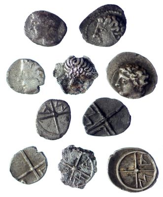 several silver coins with designs on them on a white surface