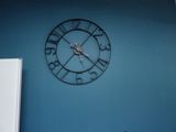 une horloge accrochée au mur au-dessus du réfrigérateur dans une cuisine