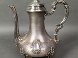 silver plated coffee pot with a bird on the top