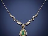 an emerald and diamond necklace on a blue background
