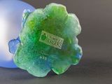 a green and blue glass ornament sitting on a table