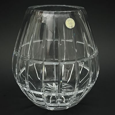 un vase en verre transparent orné d'une étiquette dorée