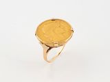 a gold ring with a coin in the middle of it