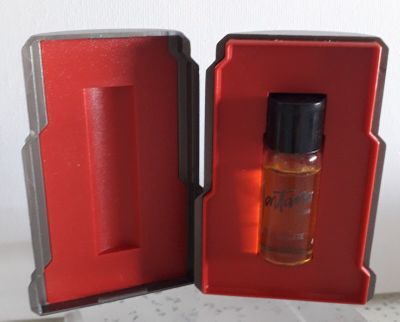 un petit flacon de parfum dans une boîte rouge