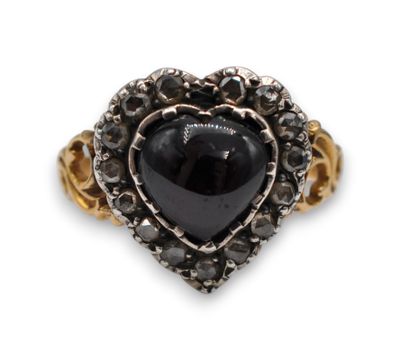 a close up of a ring with a heart shaped black stone