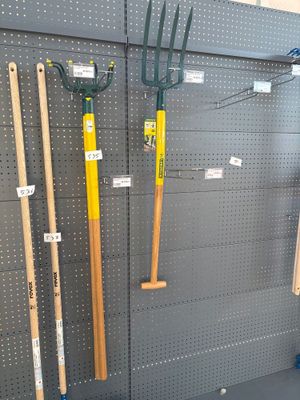 many different types of garden tools displayed on the wall