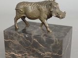 statue of a boar on a marble base on a gray background
