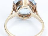 an image of a gold ring with a blue topazr stone