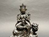 silver statue of a woman sitting on a throne with a cat