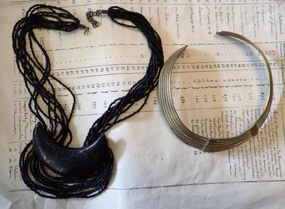 two necklaces and a bracelet laying on a piece of paper