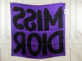 purple and black miss dior banner hanging on a wall