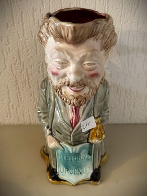 une figurine en céramique représentant un homme en train de lire un livre