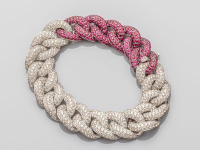 un gros plan sur un bracelet orné de diamants roses et blancs