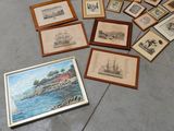 many framed pictures on the floor next to a person ' s feet