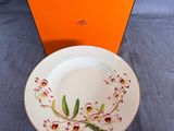 une boîte orange ornée d'une assiette blanche et d'une fleur rouge