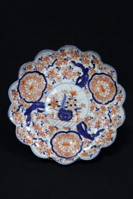 an orange and blue plate with a bird on it on a black background